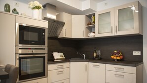 Uma cozinha moderna com eletrodomésticos embutidos, uma pia e uma fruteira no balcão.