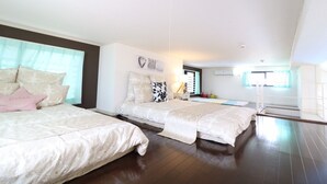 Un dormitorio con dos camas, una mesita de noche, una lámpara y una ventana con cortinas.