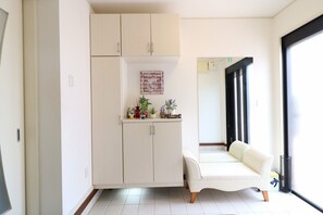 Una cocina moderna con armarios blancos, una encimera con plantas y un cartel que dice 'Welcome'.