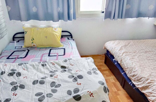 A bedroom with two beds, one with a patterned bedspread and the other with a plain one. - XIAN BnB (Jinhu)