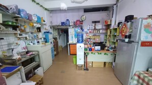 A kitchen with a refrigerator, water dispenser, and various kitchen appliances. There is a clock on the wall and a map on the refrigerator. - XIAN BnB (Jinhu)