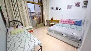 A bedroom with a bed, a desk, a chair, and a window with curtains. - XIAN BnB (Jinhu)