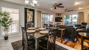 Un salon moderne avec un coin repas, un ventilateur de plafond et un téléviseur.