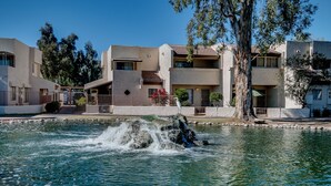 Un quartier résidentiel doté d’une piscine, d’une fontaine et d’immeubles à plusieurs étages avec des balcons.