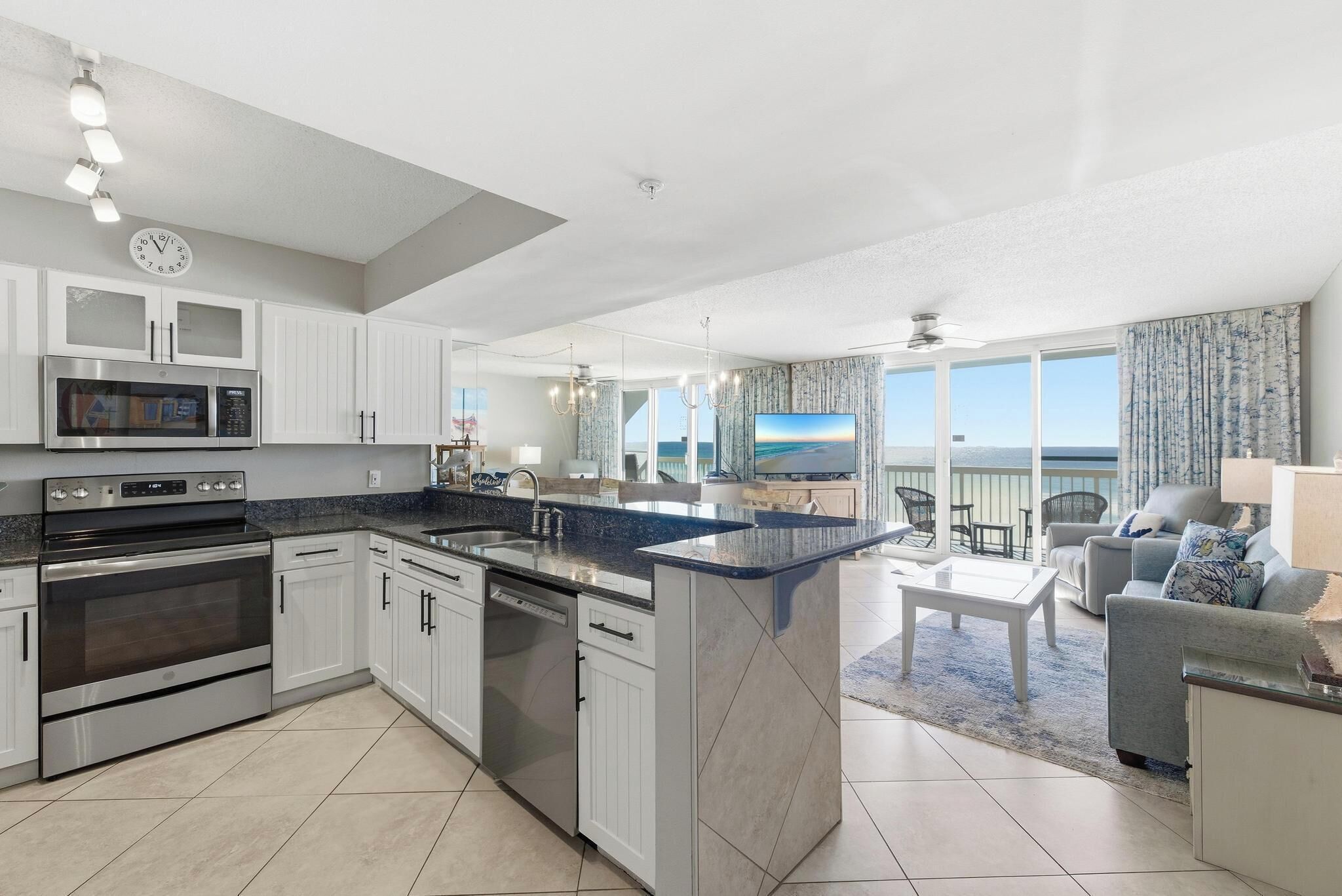 A modern kitchen with built-in appliances, a dining area with a view, and a balcony with outdoor furniture.