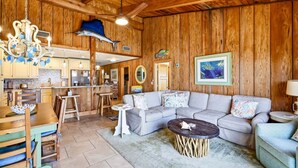 Un interior de madera con comedor, cocina y sala de estar con sofá y mesa de centro.