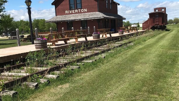 A red Riverton building with a covered outdoor seating area and a train track. - GRINDSTONE PARK, minutes from water & Beach. Hunting and fishing Largest MOOSE (Riverton)