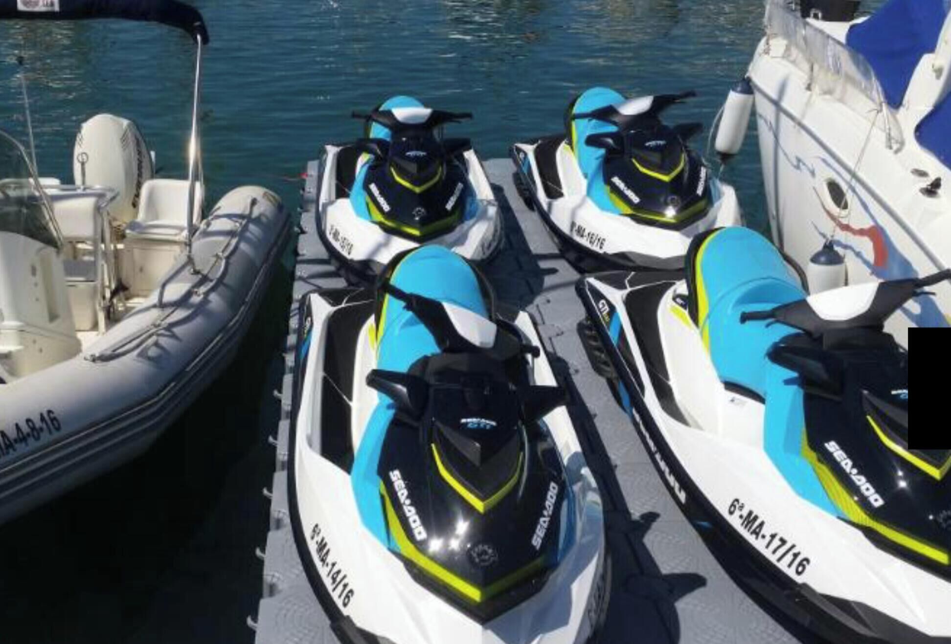 Drei Sea-Doo Wasserjets liegen in einer Marina festgemacht.