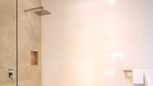 A modern bathroom with a freestanding bathtub, a glass-enclosed shower, and a towel rack.