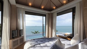 A bedroom with a large bed, a TV, and a view of the ocean. - Cape Fahn Hotel – Private Islands Samui (Koh Samui)