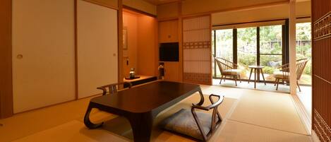 Una habitación tradicional japonesa con suelo de tatami, una mesa baja y puertas correderas.