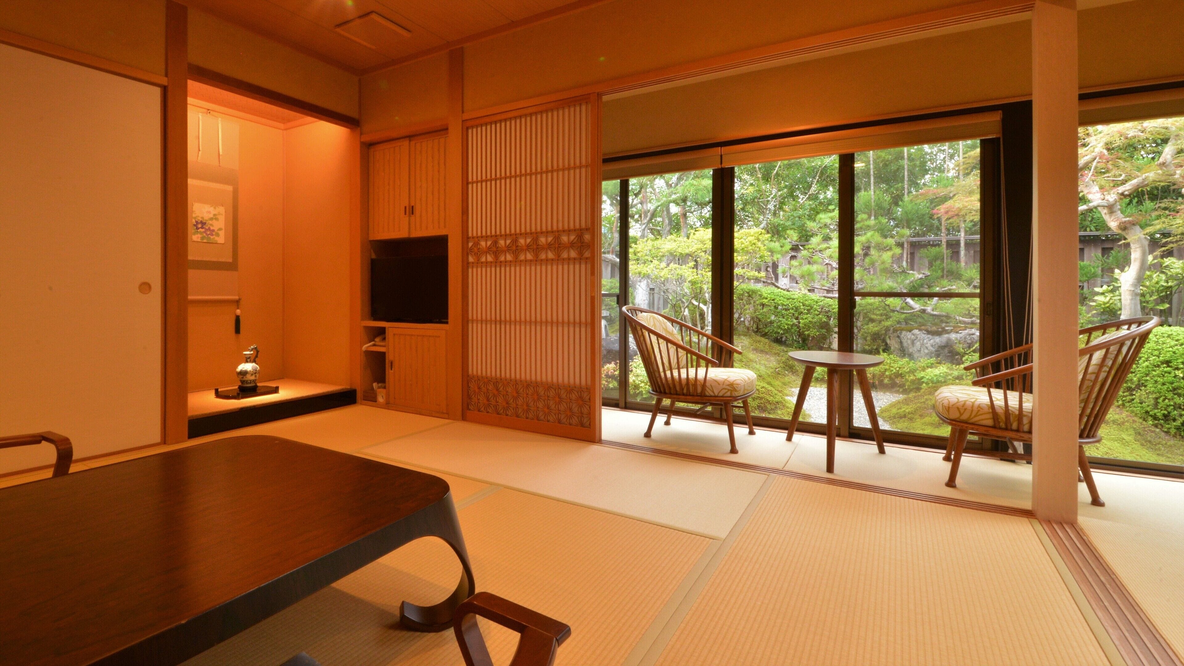 Une pièce de style japonais traditionnel, avec un sol recouvert de tatamis, une table basse et deux chaises.