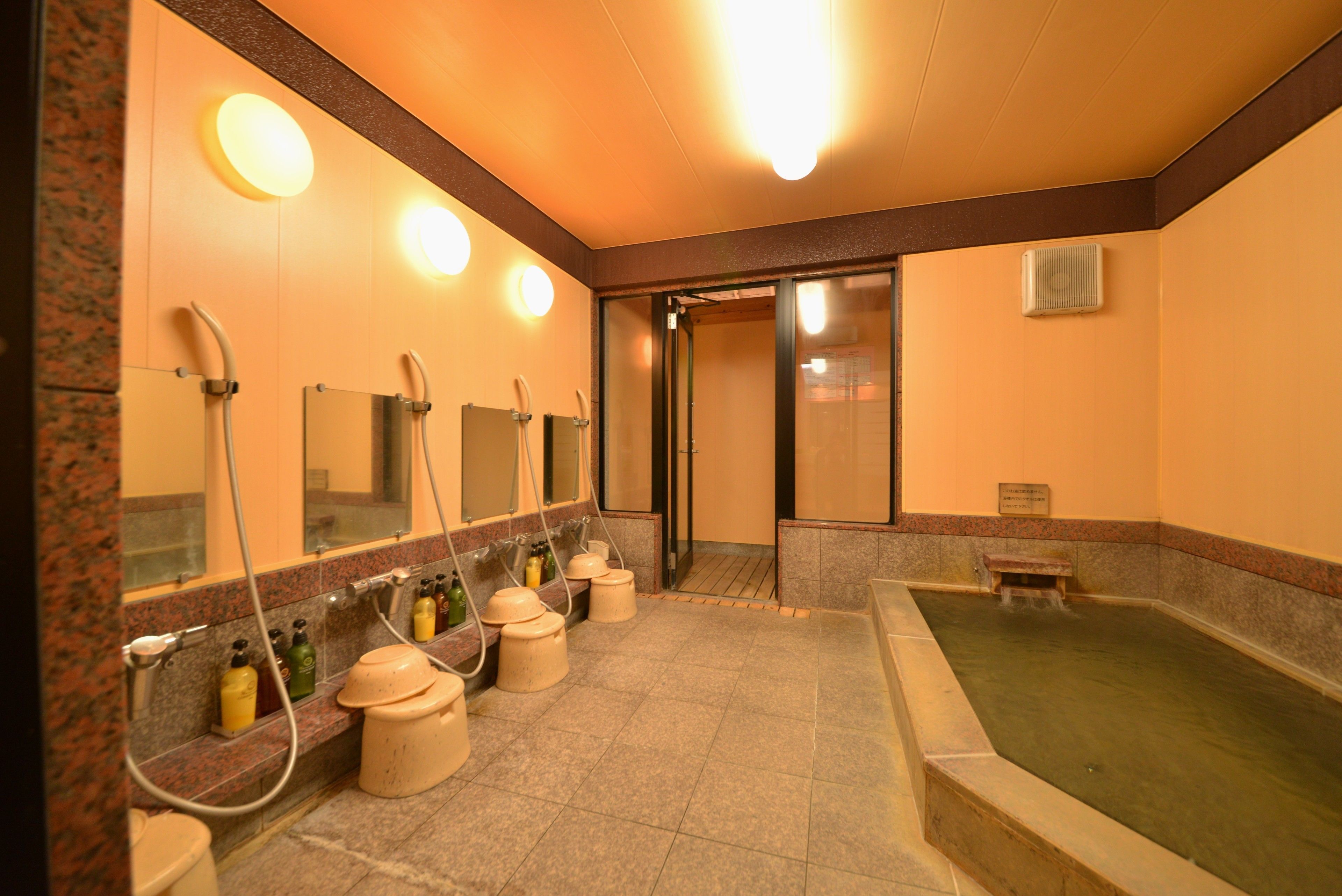 A public bath area with multiple sinks, mirrors, and a hot tub.