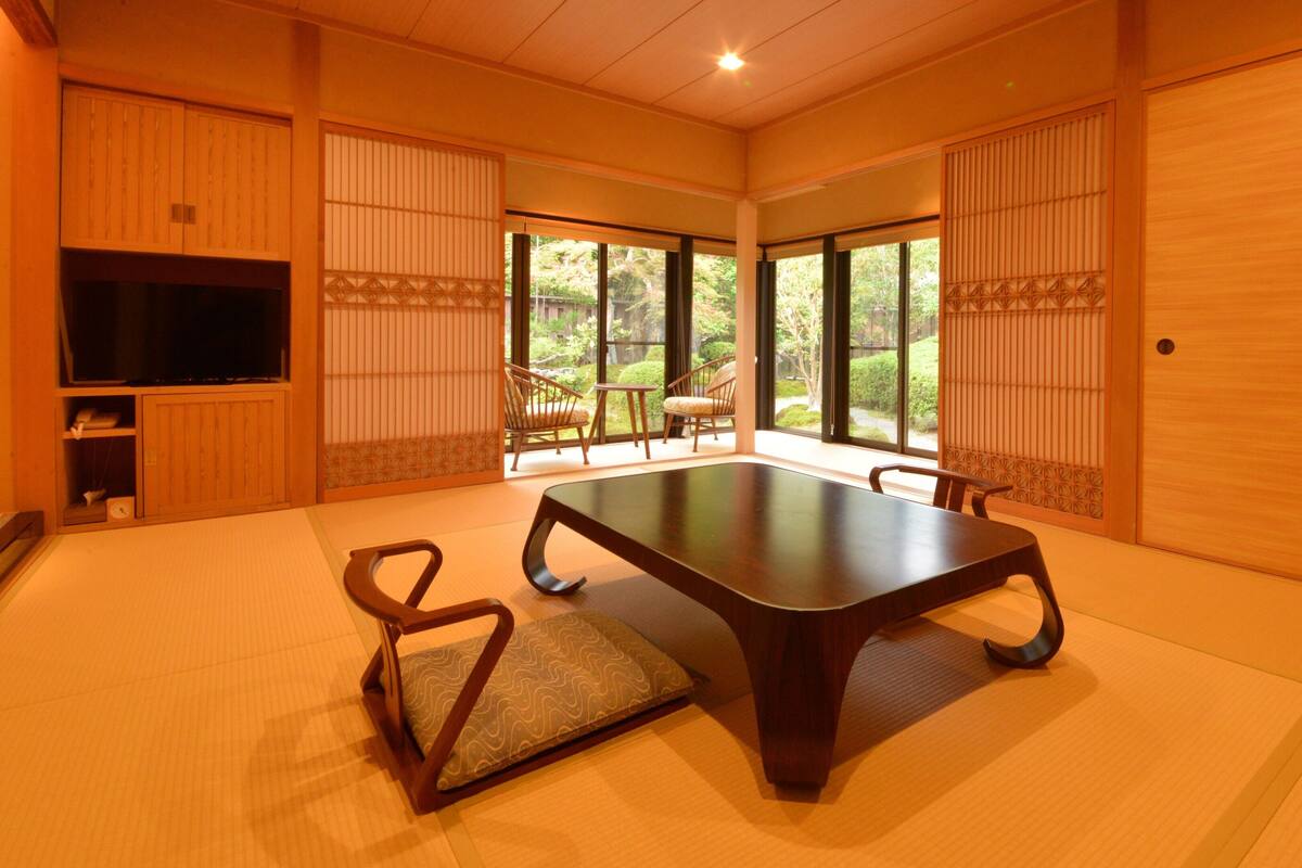 A traditional Japanese-style room with tatami flooring, a low table, and sliding doors.