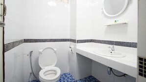 A bathroom with a toilet, sink, and mirror. - Memory Place (Krabi)