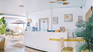 Ampla sala de estar com piscina central, assentos confortáveis e um balcão de recepção.