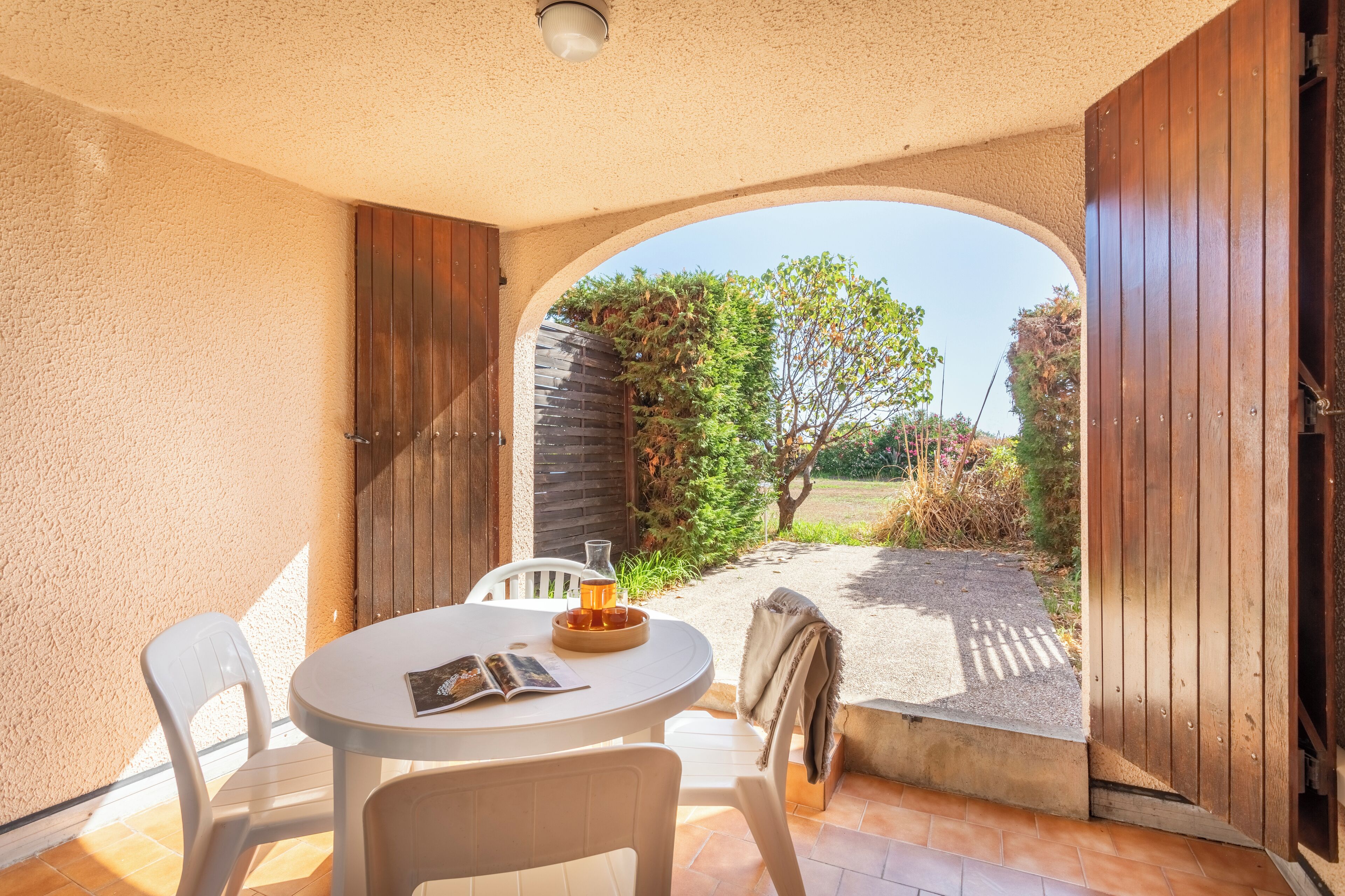A patio with a round table, chairs, and a book.