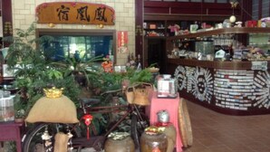 A traditional Chinese restaurant interior with a bicycle, large vases, and a tiled wall. - Phoenix Landscaping B&B (Yuanshan)