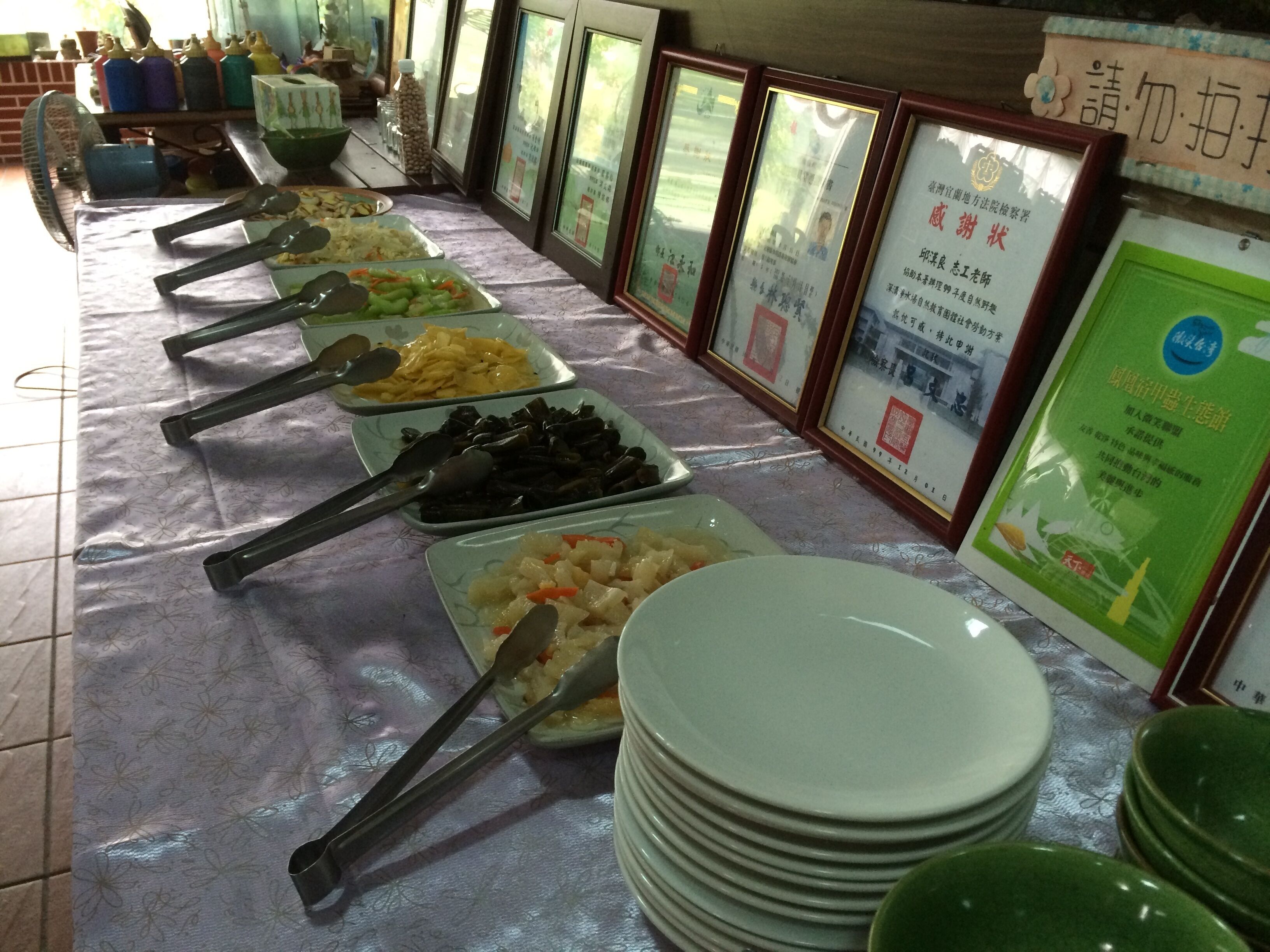 Une table de buffet avec différents plats et assiettes.
