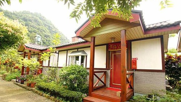 A traditional Japanese-style building with a wooden porch and a red door. - Phoenix Landscaping B&B (Yuanshan)