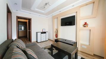 Superior Suite, 1 Bedroom | Living room | 60-inch TV with cable channels