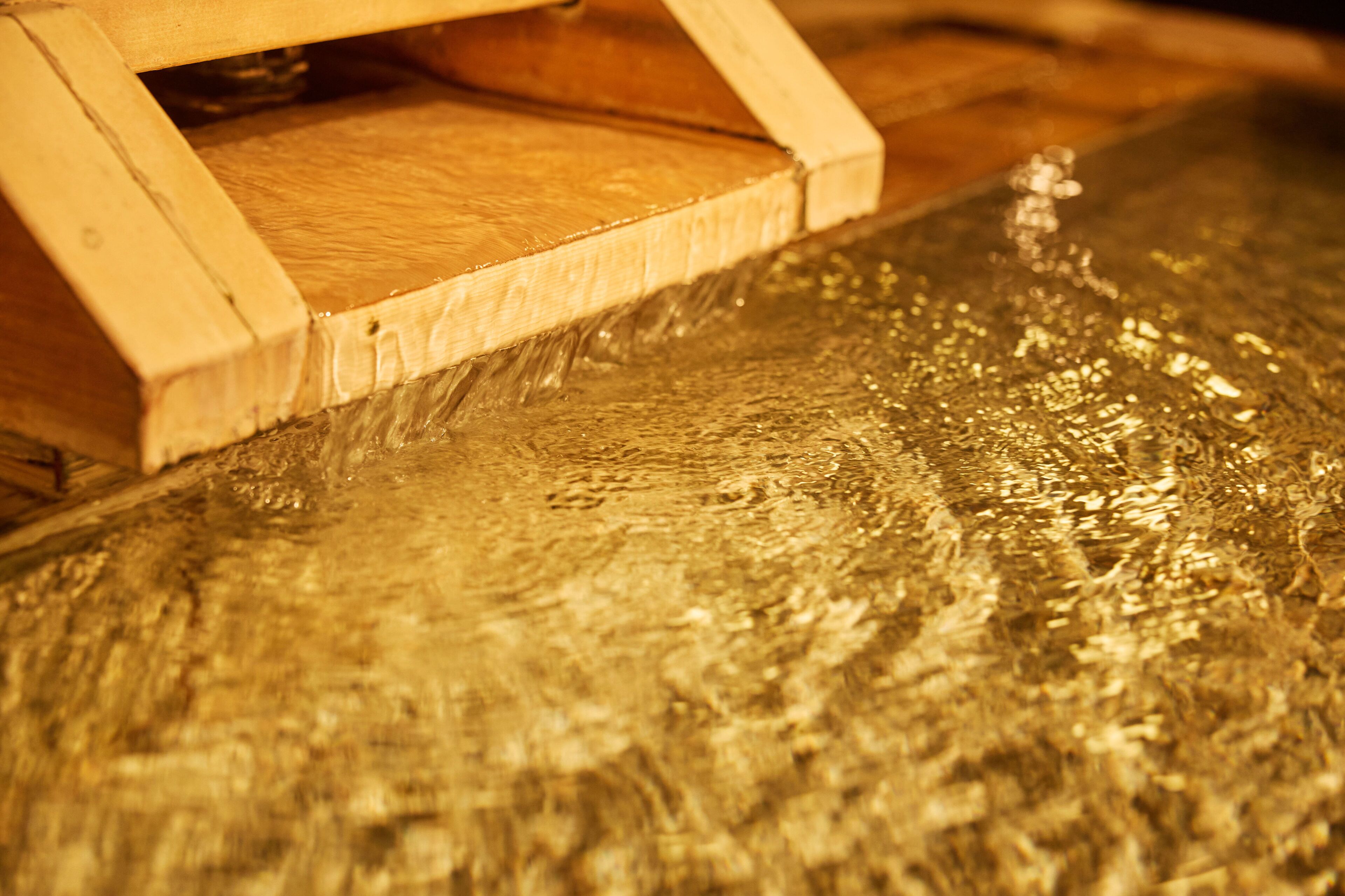 A close-up of a wooden structure with a water feature.