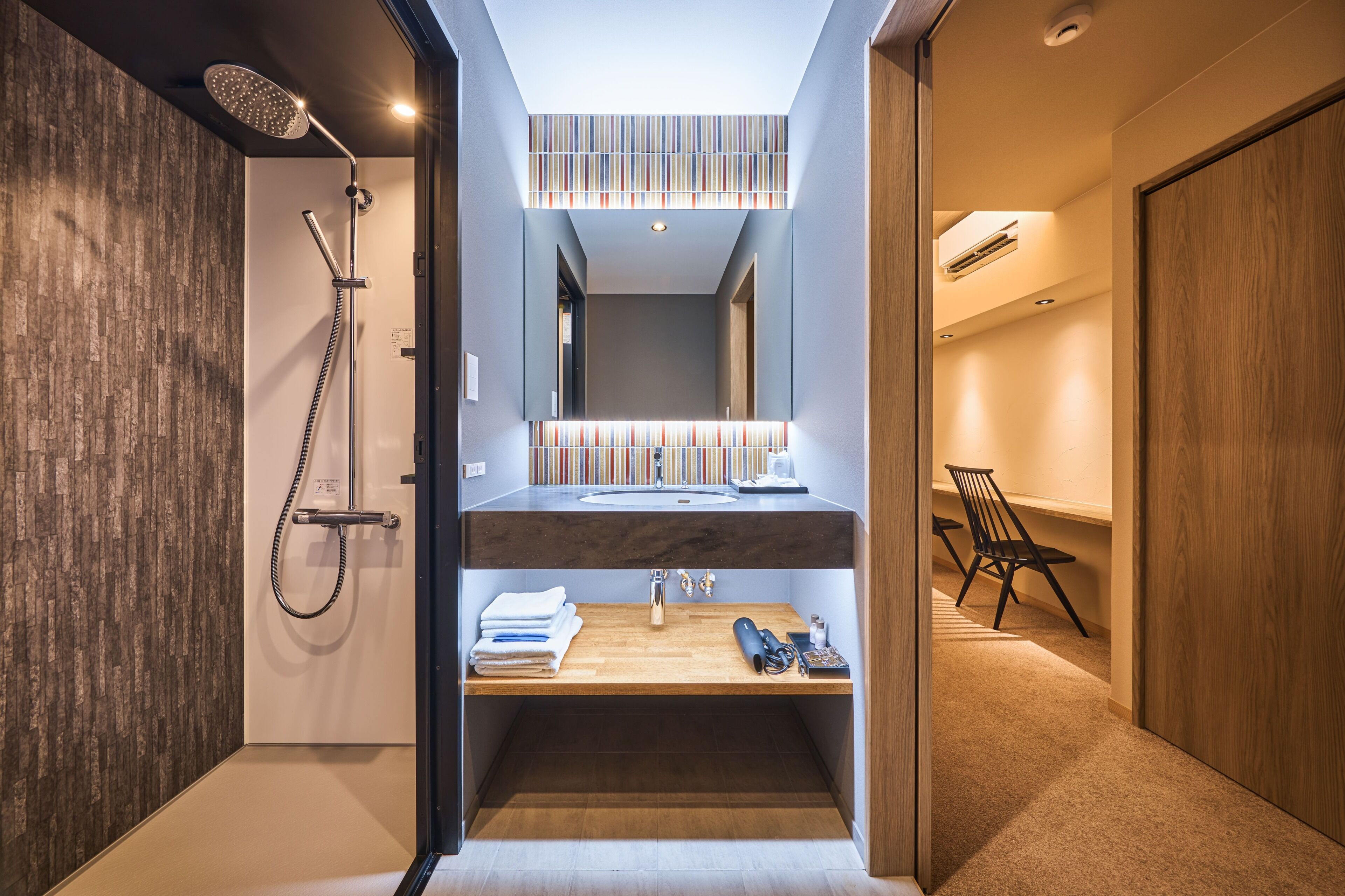 A modern bathroom with a shower, vanity, and a mirror above the sink.