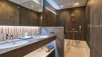 A modern bathroom with dual sinks, a shower, and a glass-enclosed jacuzzi.