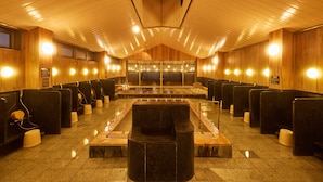 Un baño público con paredes de madera, varios lavamanos y bancos.