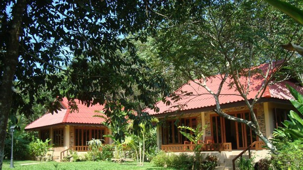 A bungalow with a red roof, surrounded by lush greenery and a well-maintained lawn. - Happy Garden villa (Krabi)
