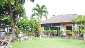 A building with a tiled roof, surrounded by a well-maintained lawn and several trees. - Levante (Surat Thani)
