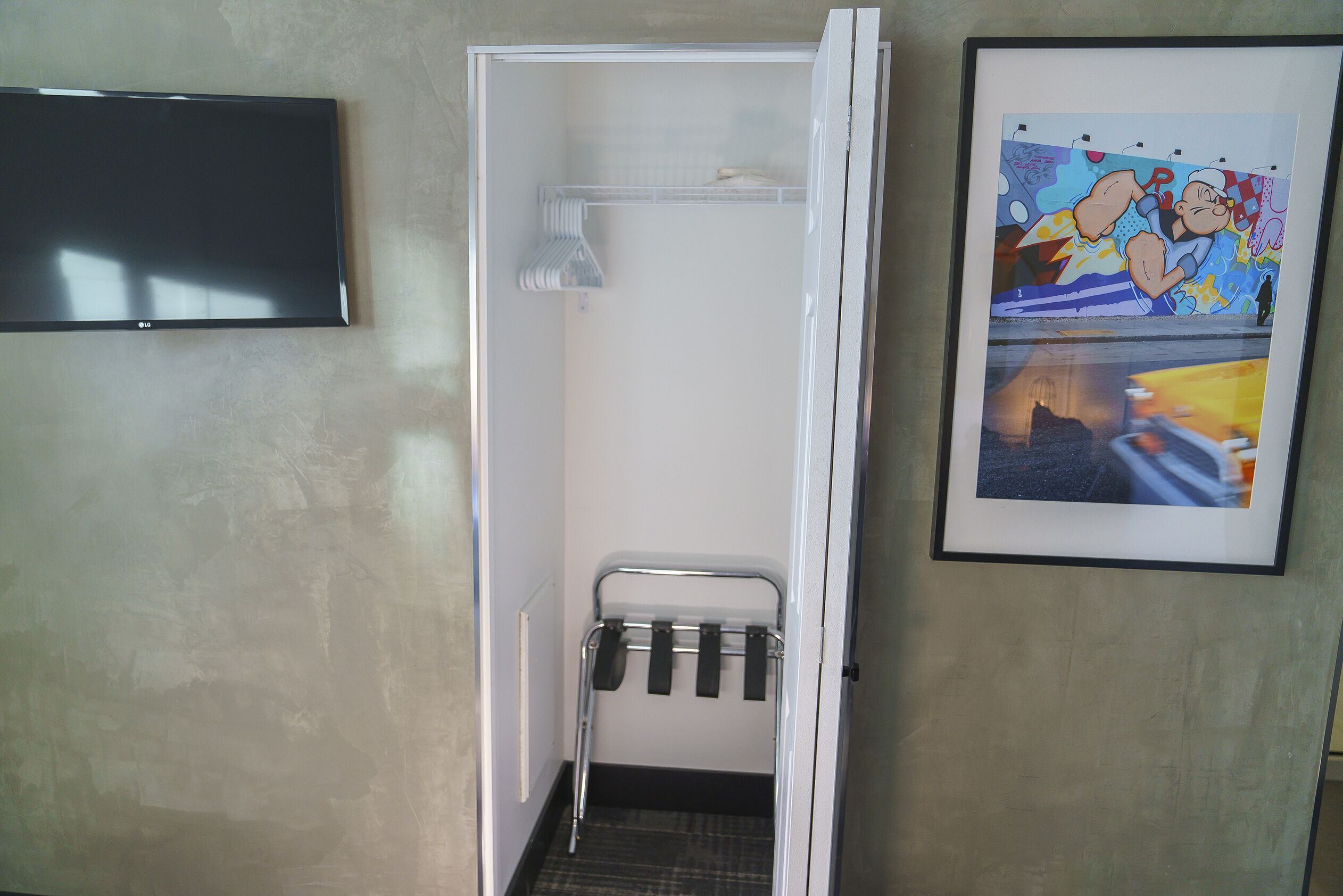 A small bathroom with a shower, a towel rack, and a framed picture on the wall.