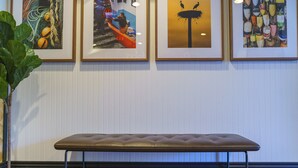 Een bank in een kamer met kunstwerken in lijsten aan de muur.