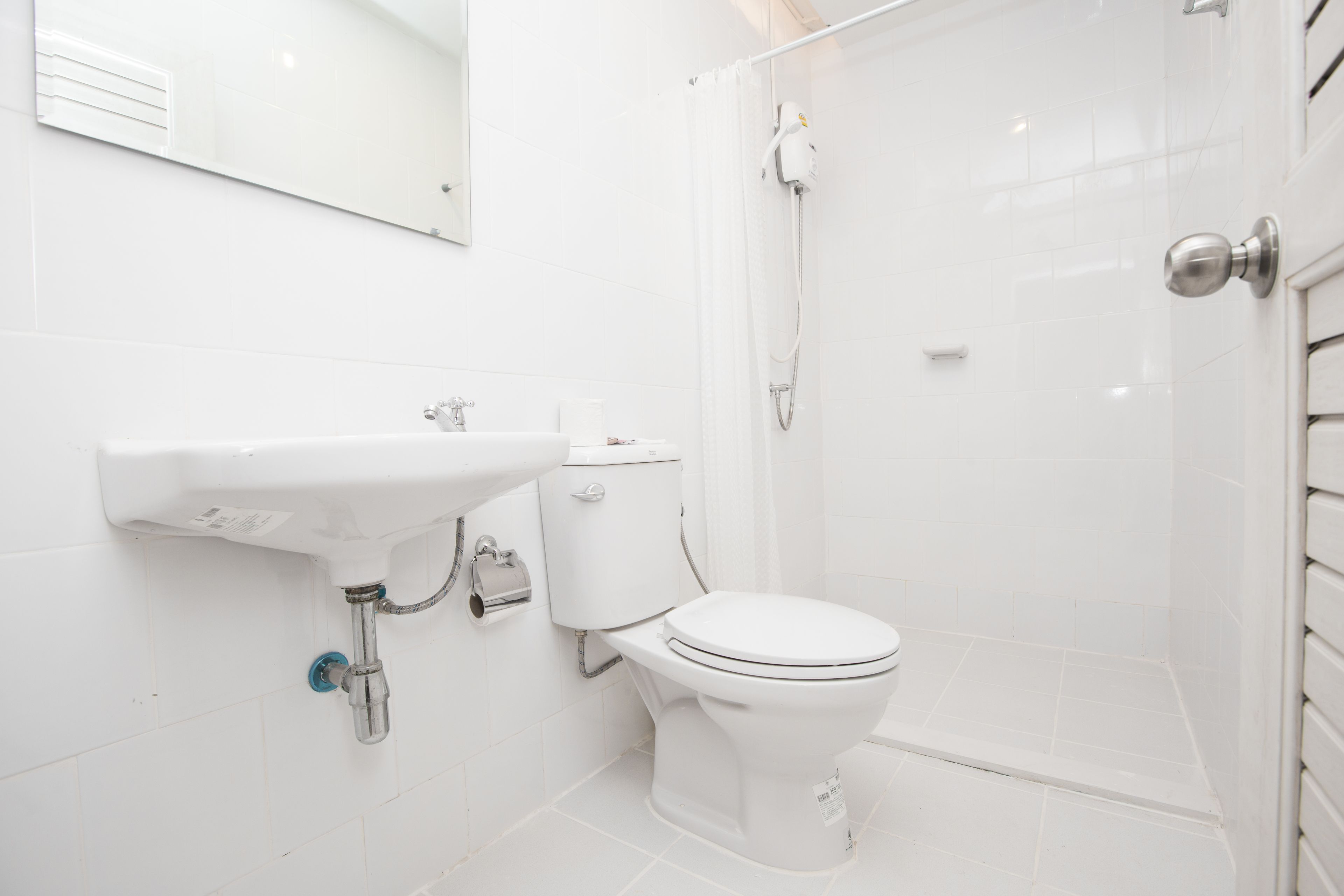 A modern bathroom with a white sink, toilet, and shower.