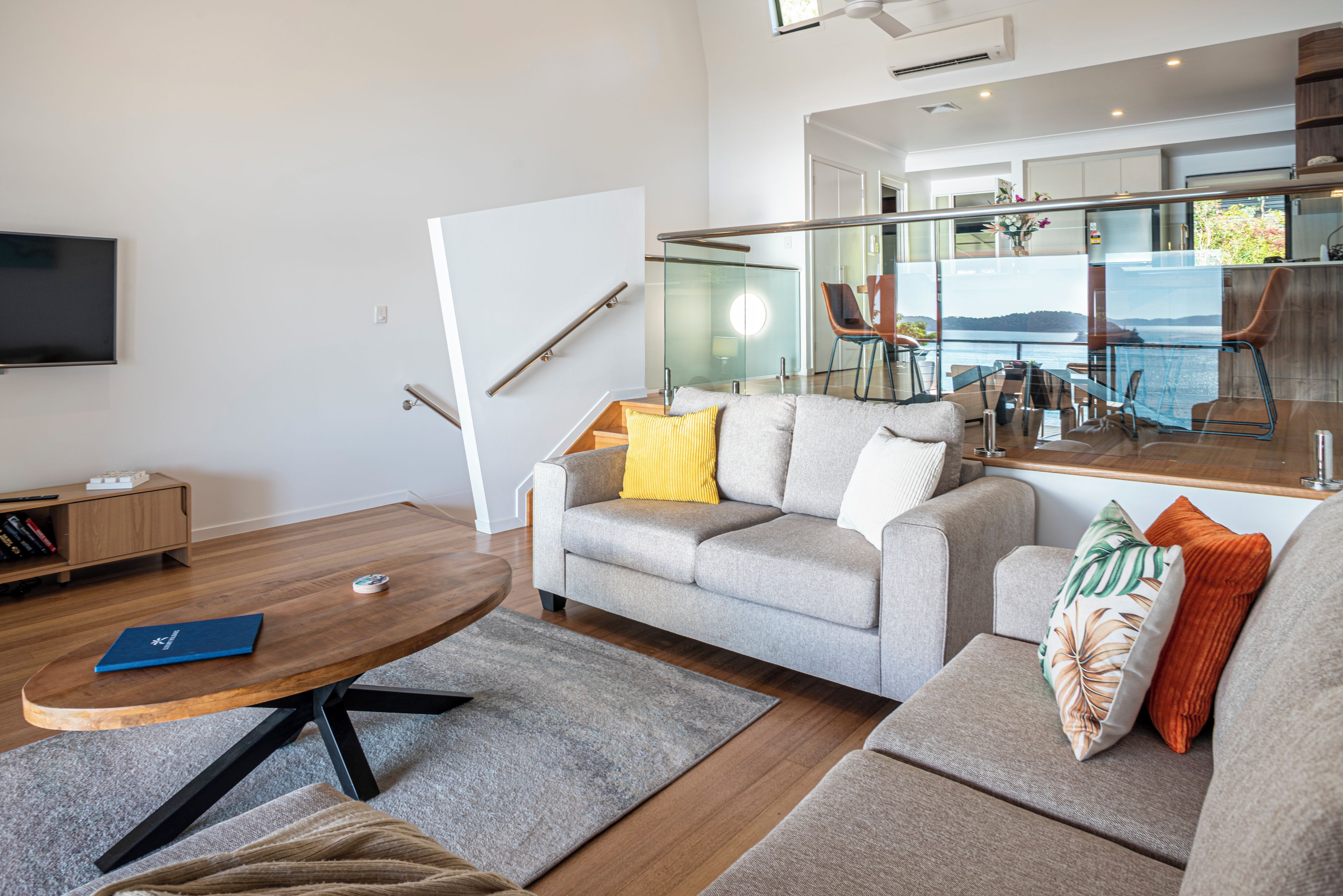 A modern living room with a grey sofa, a coffee table, and a television.