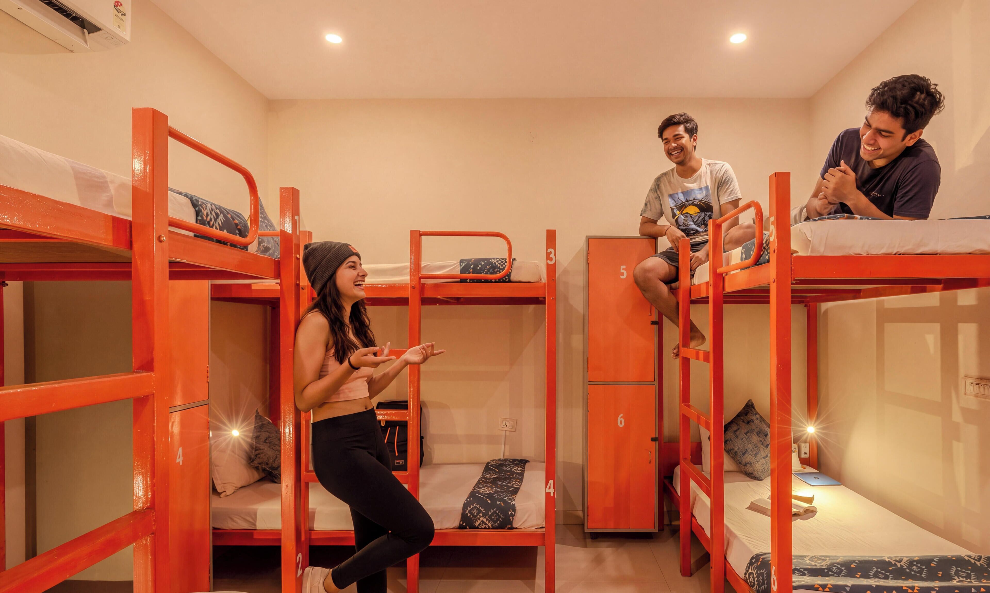 Una habitació de dormitori amb llits superposats, un escriptori petit i una cadira.