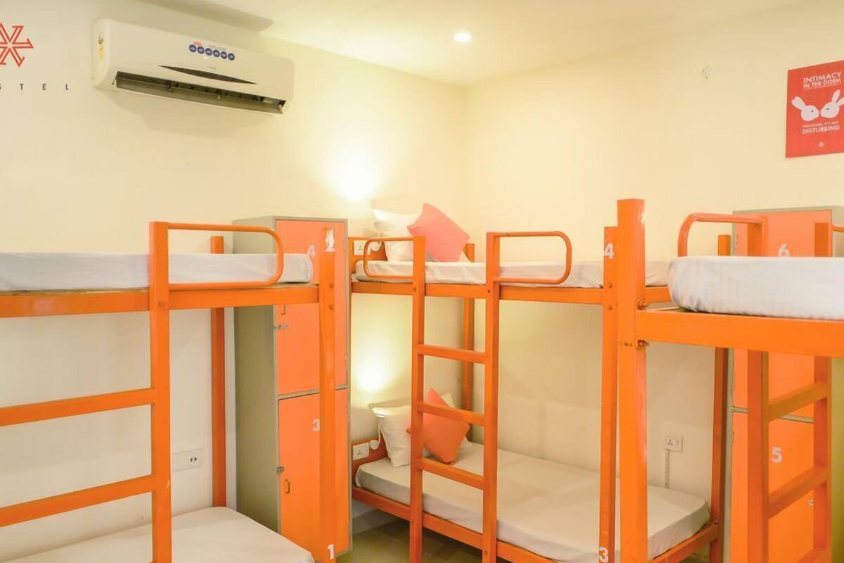 Un dormitorio con literas, un equipo de aire acondicionado y un cartel en la pared.