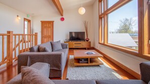A modern living room with a sofa set, a TV, and a wooden coffee table. - Cocoa Niseko (Kutchan)