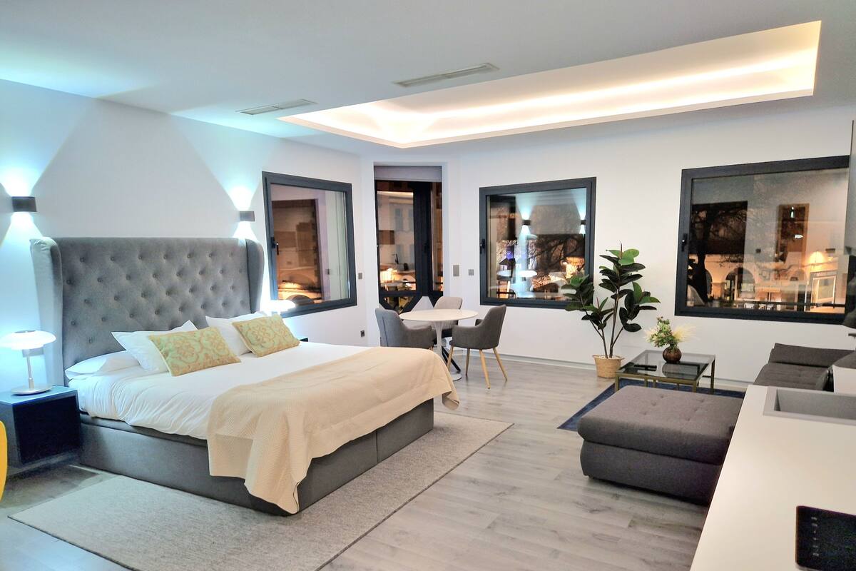 Ein modernes Schlafzimmer mit einem großen Bett, einem Schreibtisch und einer Sitzecke.