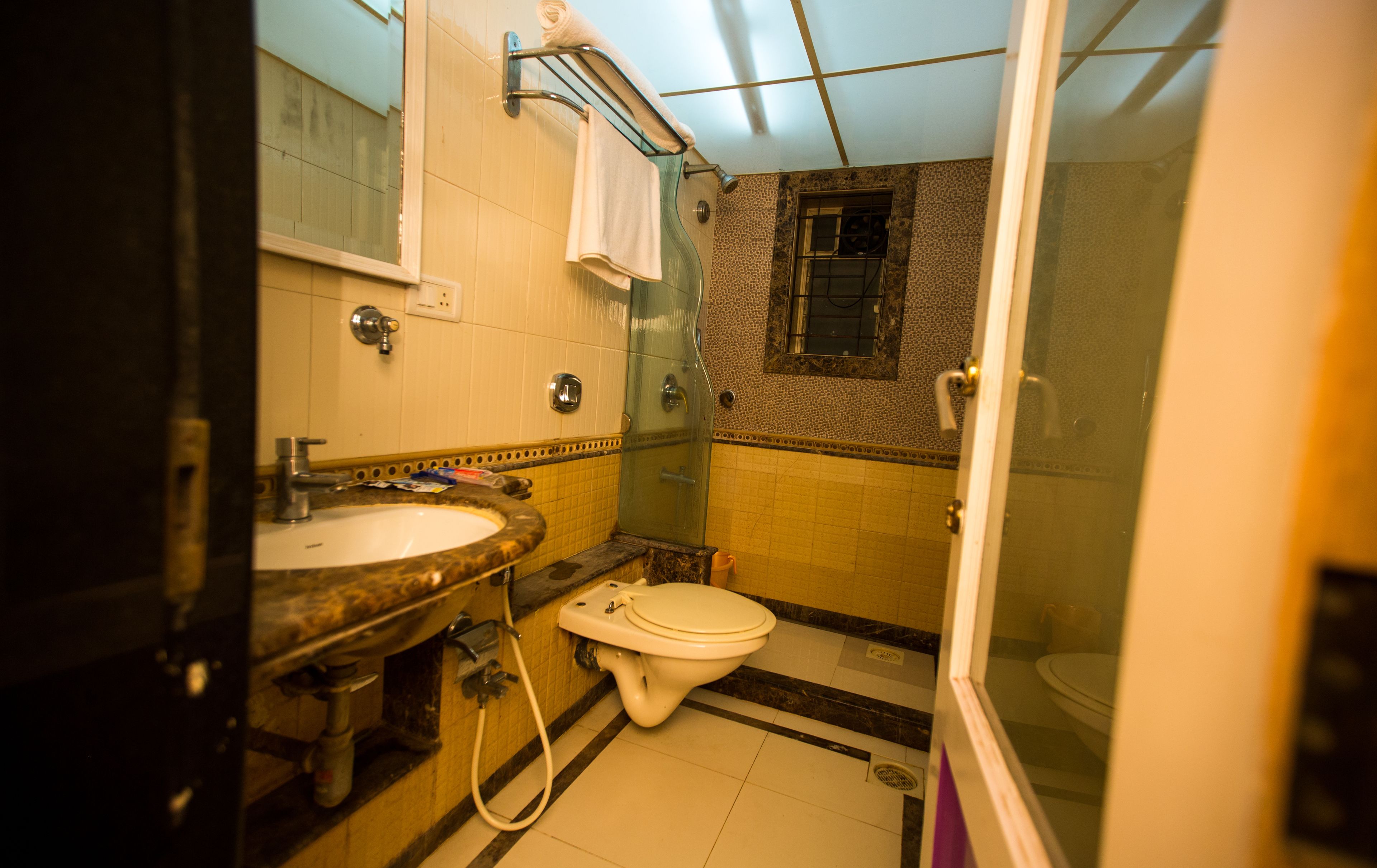 A compact bathroom with a sink, toilet, and shower.