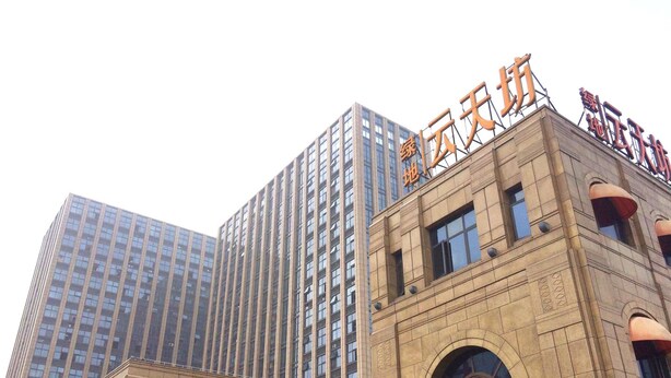A modern building with a prominent sign and a tall adjacent skyscraper. - Yunzu Aparthotel - Huanlegu Branch (Shanghai)