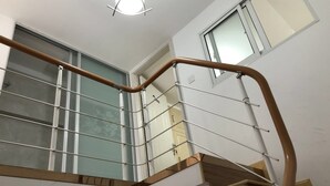 A modern staircase with metal railings and wooden handrails, leading to a balcony with glass railings. - Yunzu Aparthotel - Huanlegu Branch (Shanghai)