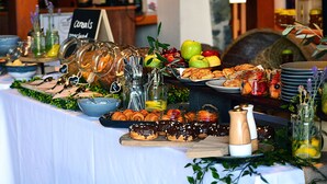 A buffet table with various food items, including pastries, fruits, and condiments. - Sanctuary By Sirromet (Mount Cotton)
