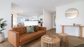 A modern living room with a sofa, coffee table, and a round mirror on the wall.
