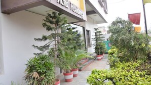 Un edificio con un cartel que dice 'Nand Residency' y plantas en macetas al frente.