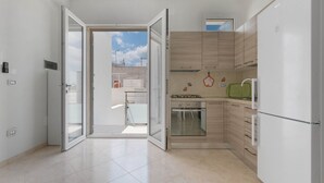 Una cocina moderna con distribución abierta, estufa a gas, horno y refrigerador.