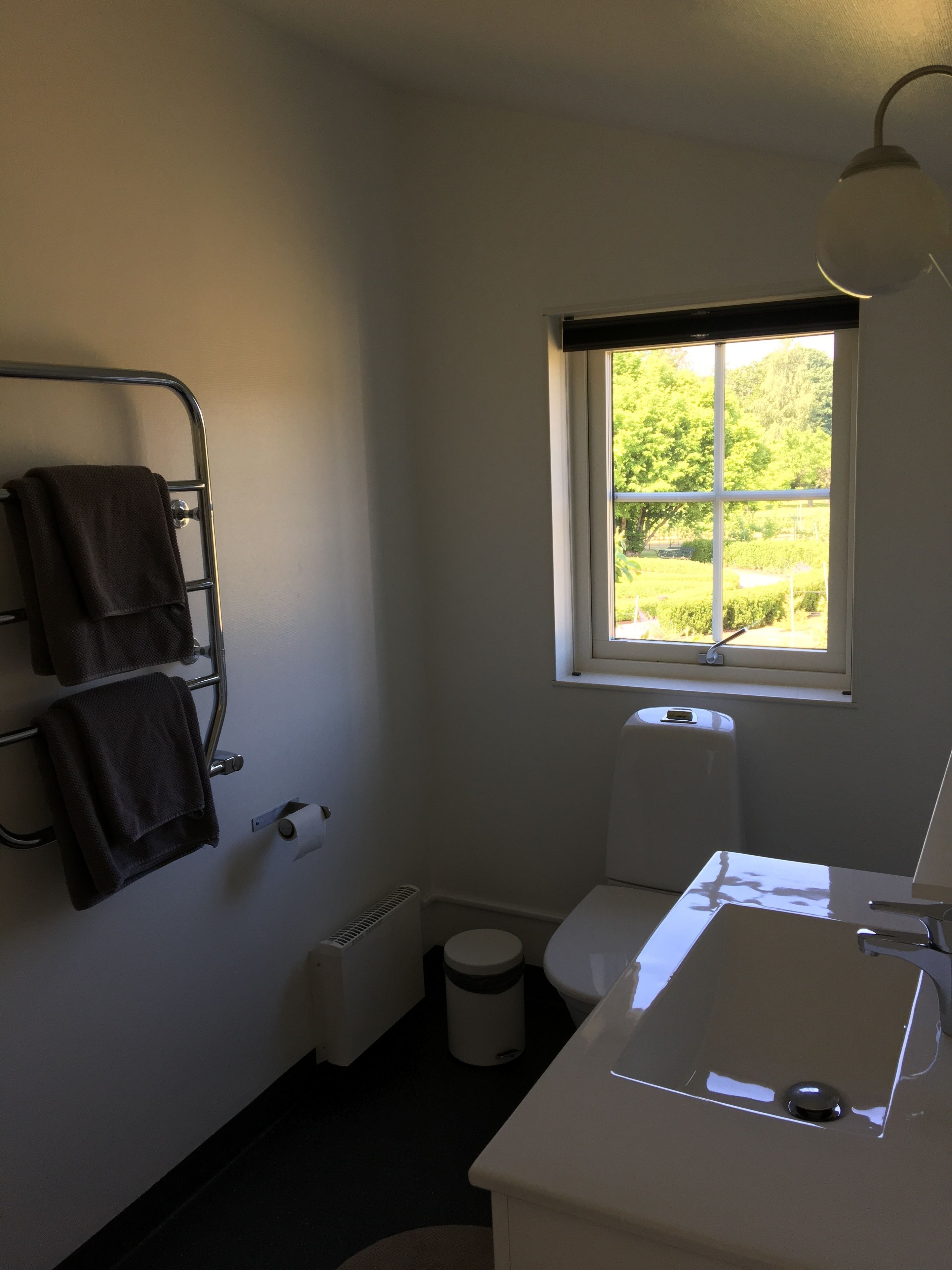 A small, clean bathroom with a toilet, sink, and towel rack.
