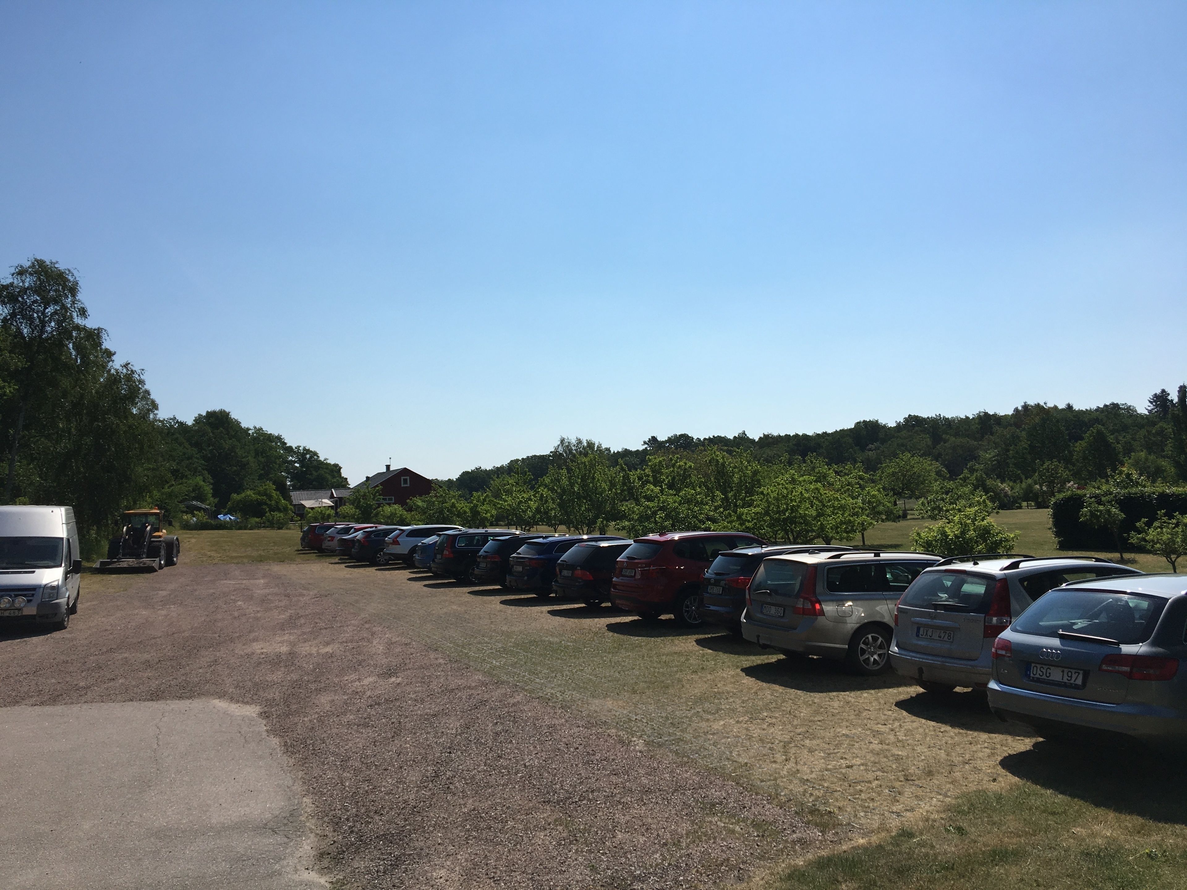 Ein Parkplatz mit mehreren Autos und einem weißen Lieferwagen.