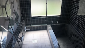 A bathroom with black tiled walls, a window with frosted glass, a shower area, and a tiled floor. - VOYAN Resort FUJIYAMANAKAKO GEKKOSO (Yamanakako)