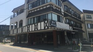 A multi-story building with a prominent black and white facade, large windows, and a balcony. - VOYAN Resort FUJIYAMANAKAKO GEKKOSO (Yamanakako)